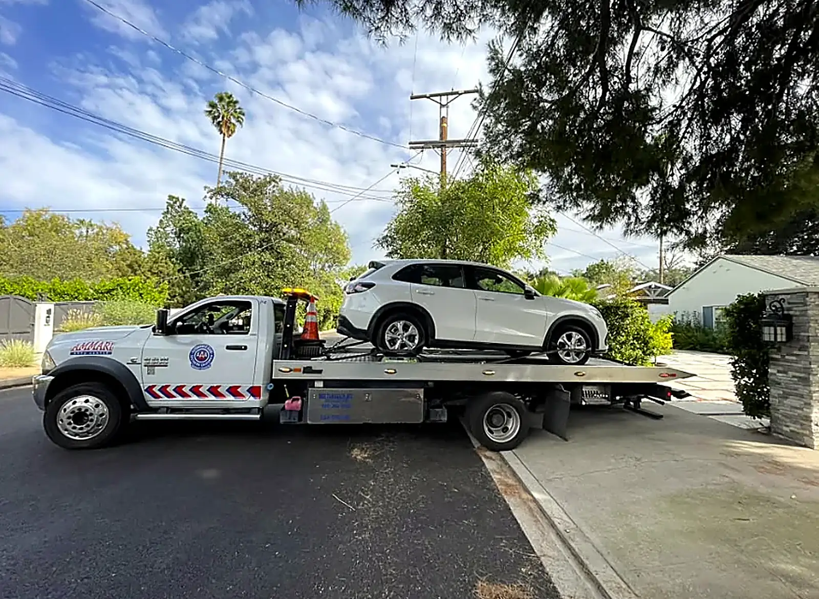 Ammari flatbed tow truck loading an SUV
